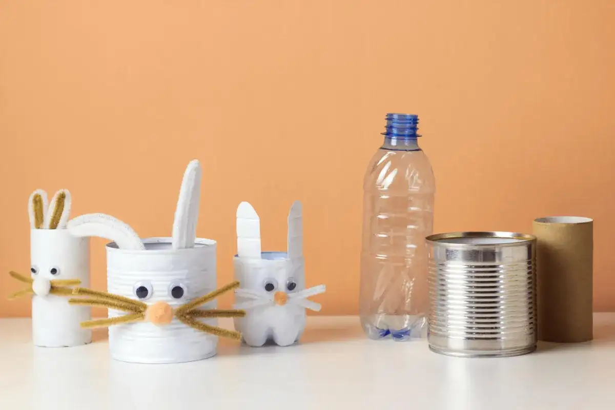 Urocze **zabawki z recyklingu** w kształcie króliczków, wykonane z puszek i butelek. Wesołe uszka i oczka dodają im charakteru.